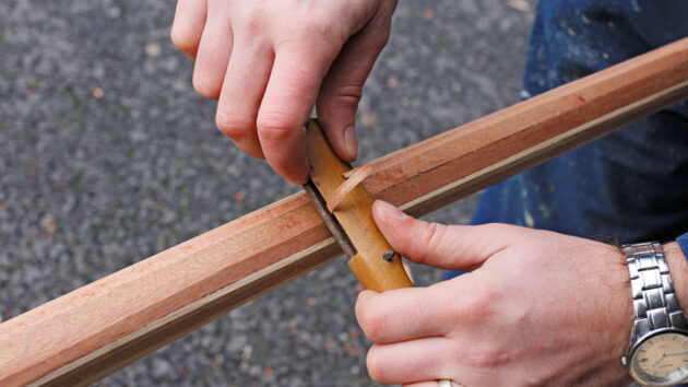 A man making a tiller round for a boat