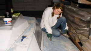 A woman stripping deck paint