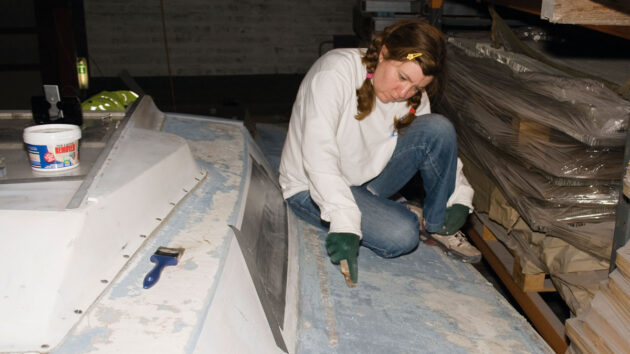 A woman stripping deck paint