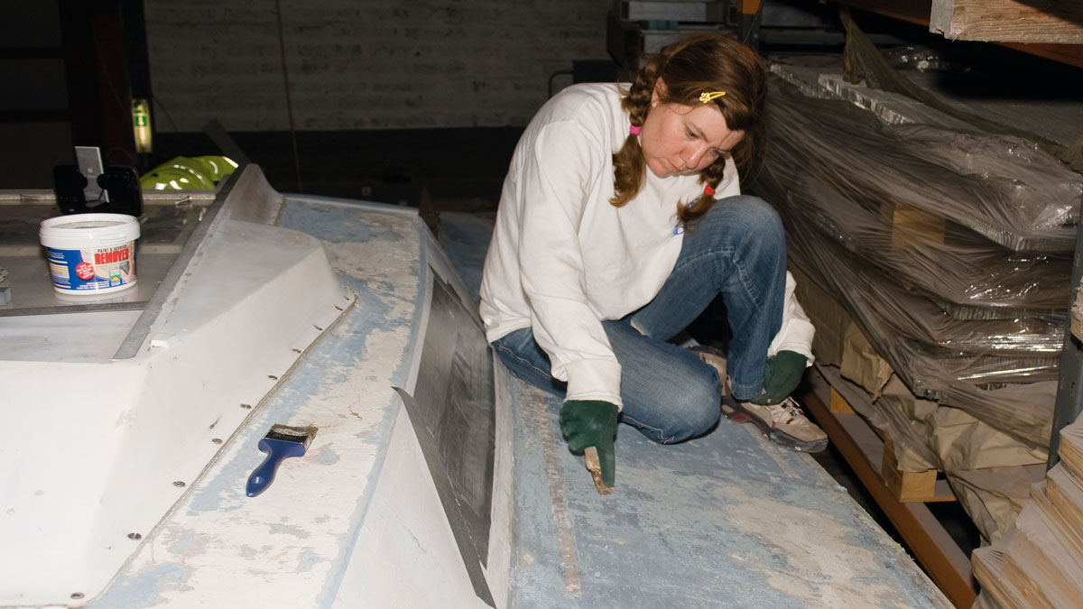 A woman stripping deck paint
