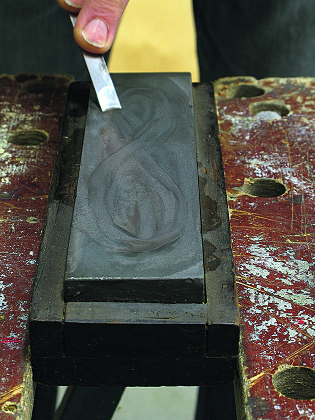 A man demonstrating how to sharpen a chisel