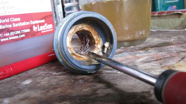A screwdriver being used to descale pipes on a boat