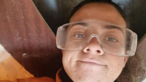 A woman wearing oversized protective eyewear while boat building