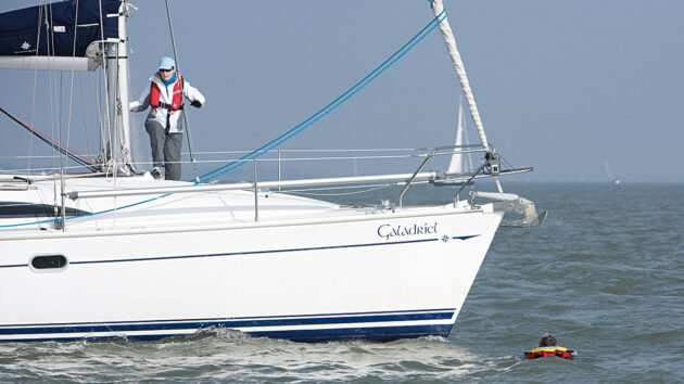 A woman on a boat approaching a man in the water
