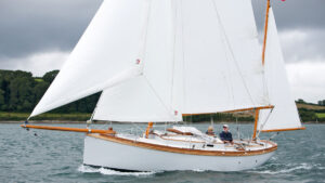 A Golant Yawl being sailed by a man and a woman off the coast