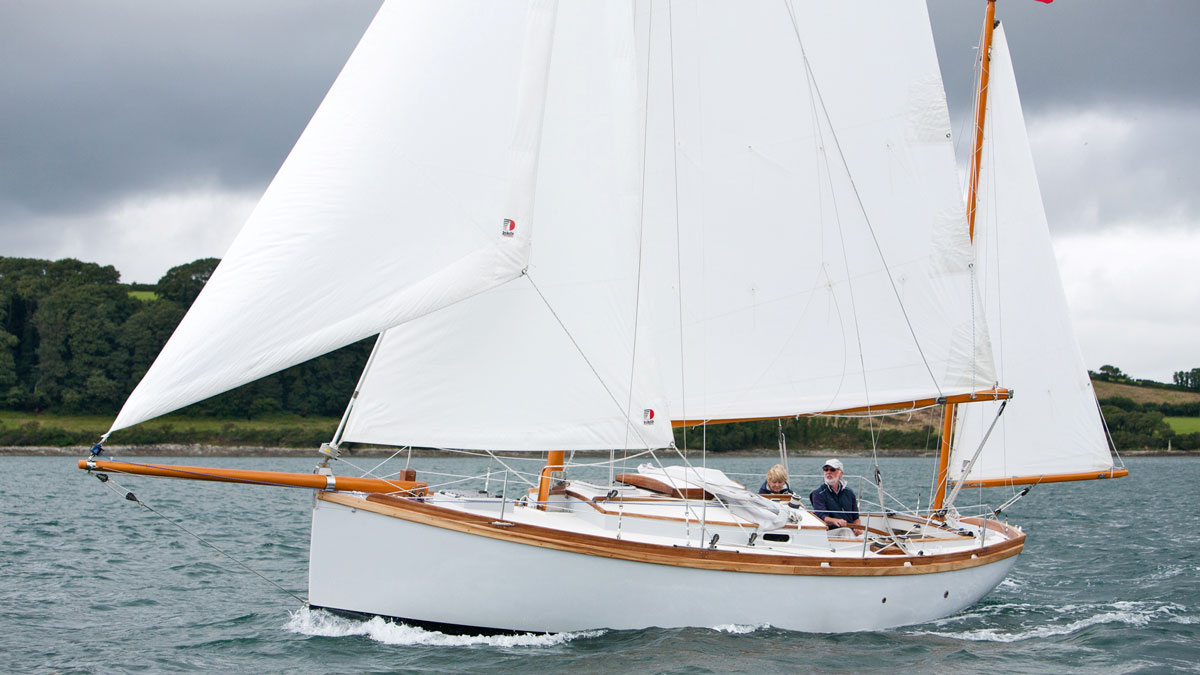 A Golant Yawl being sailed by a man and a woman off the coast