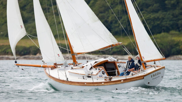A man and a woman sailing a Golant Yawl