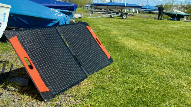 A folding solar panel set up in a boat park
