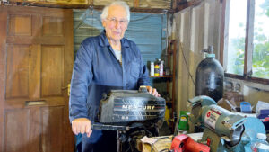 A man about to carry out a 2-stroke outboard service