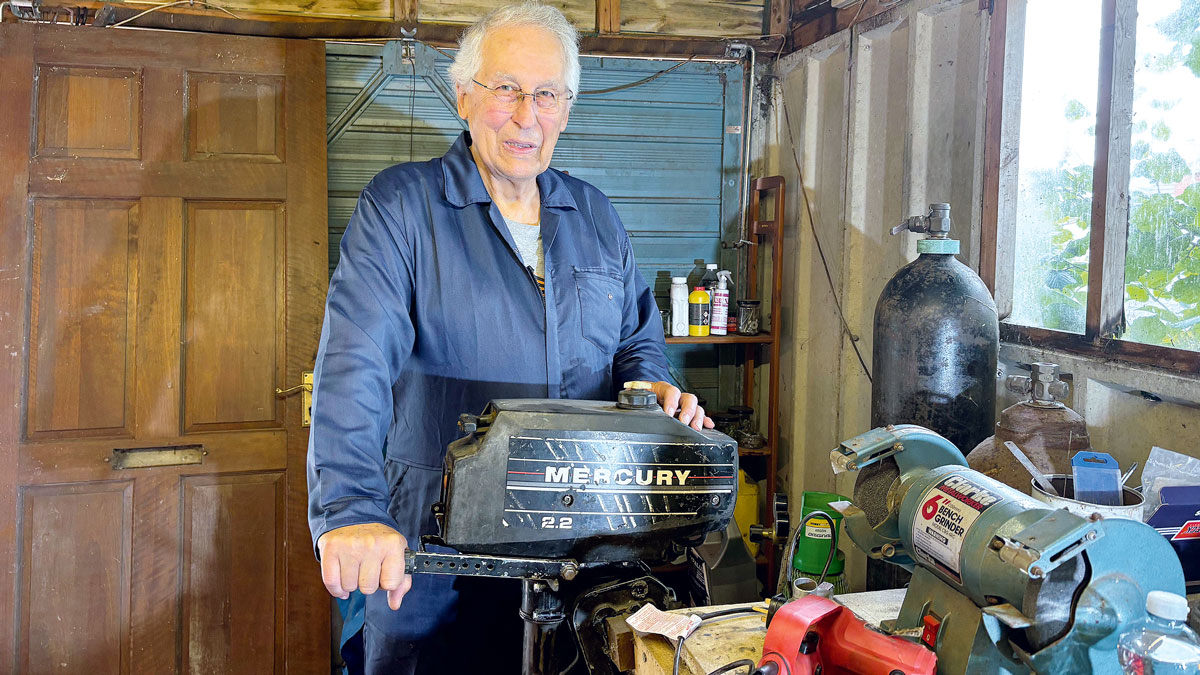 A man about to carry out a 2-stroke outboard service