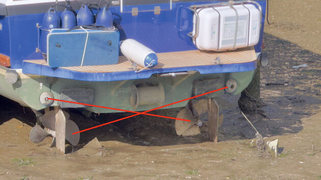 The aft end of a motorboat dried out on mud