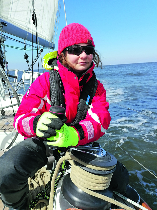 A woman winding a winch on a boat