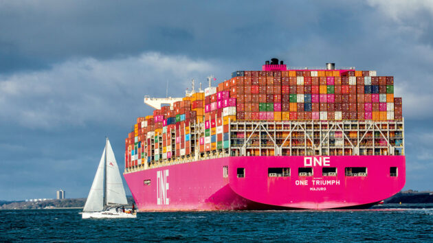 A yacht passing by a container ship