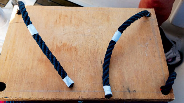 Spliced rope being threaded through a hole in a piece of wood