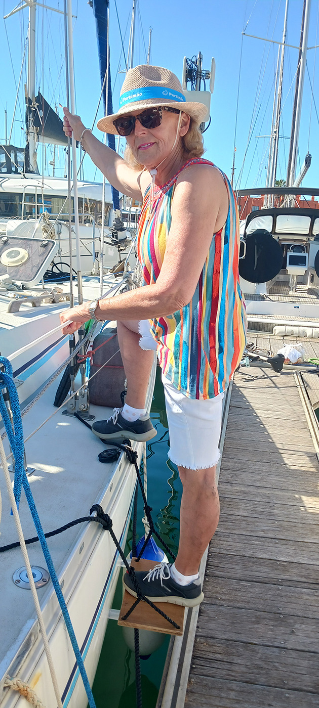A woman stepping onto a yacht from a pontoon using a boat step