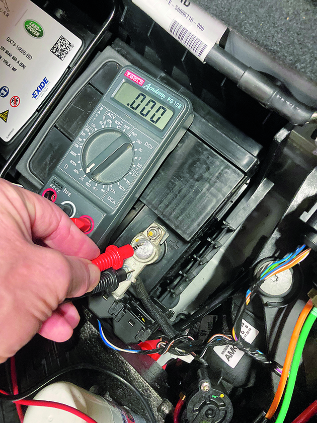 A man using a multimeter while working on his boat electrics