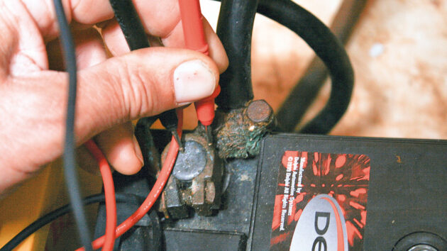 A person performing a voltage drop test on a boat