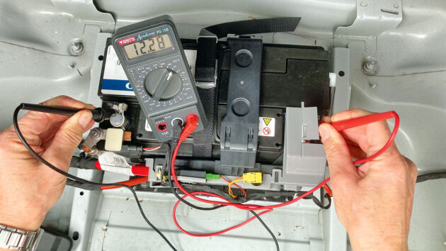 A mutimeter being used on a boat battery by a man testing his boat electrics