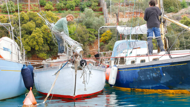 A person mast unstepping their boat while it is on the water