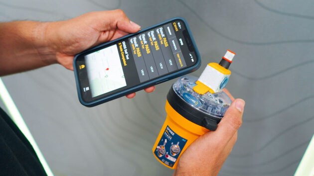 A sailor holding a EPIRB and a mobile phone