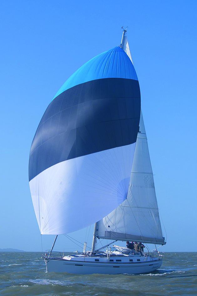 A yacht sailing with a white, black and blue sail