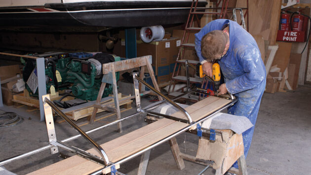 A ,man fitting a boat swimming platform to a motorboat