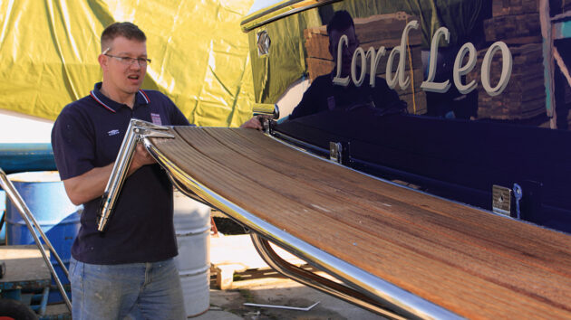 A man fitting a boat swimming platform to a motorboat