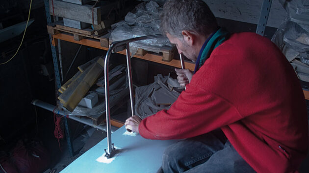 A man fitting deck gear to a boat