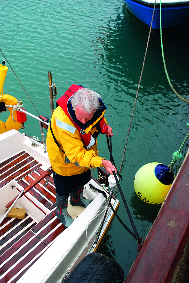 a man tying a boat to a harbour wall