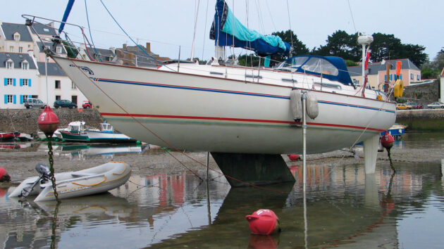 a yacht drying out on legs on a beach