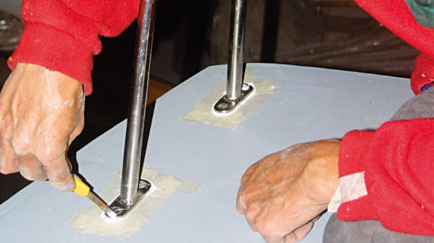 A man fitting deck gear to a boat