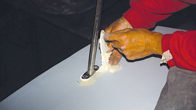A man fitting deck gear to a boat