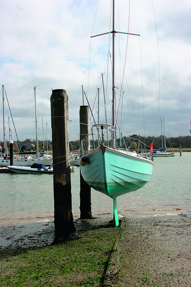 A yacht drying out against piles 