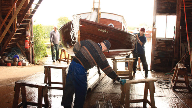 Men preparing to winterise a wooden boat