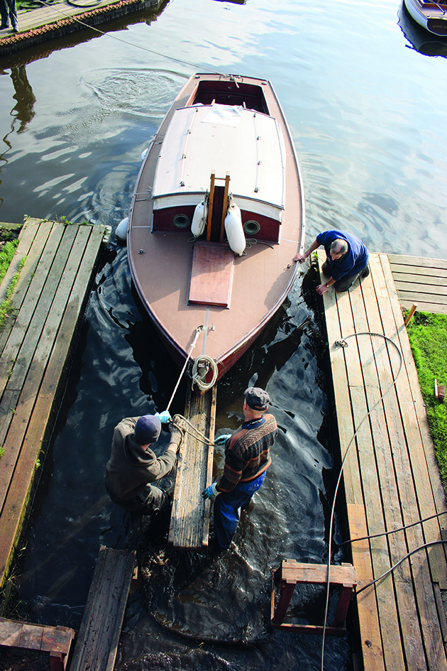 Men hauling out a wooden boat