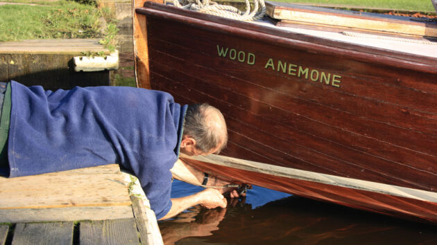 A man hauling out a wooden boat