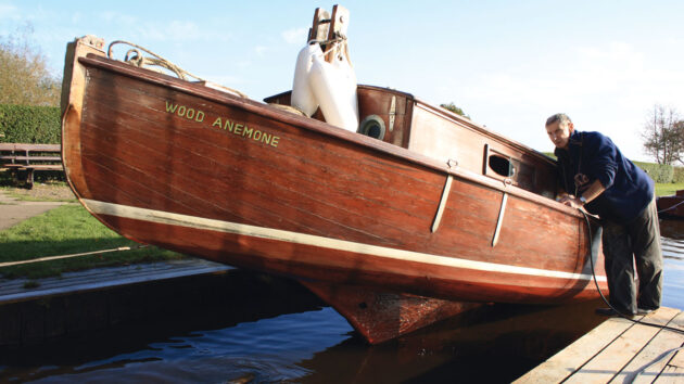 A man hauling out a wooden boat
