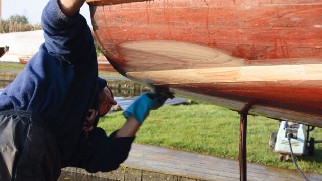 A man hauling out a wooden boat