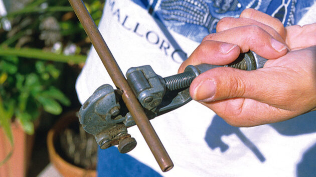A tube cutter being used on a piece of pipe