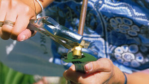 A woman tightening a nut on a compression joint wiht a spanner
