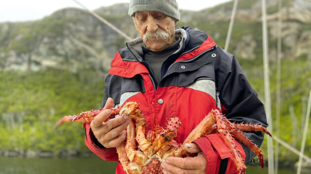 A man holding a king crab on a boat in the Beagle Channel