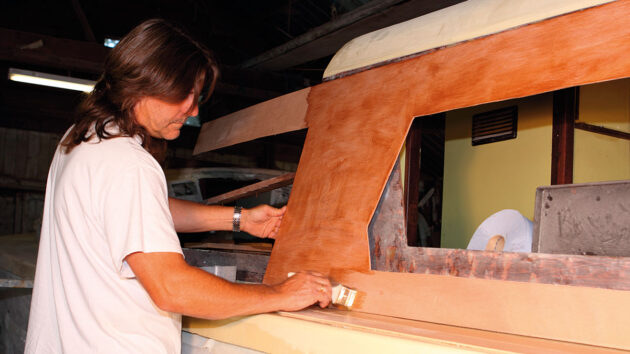 A man applying epoxy to a boat