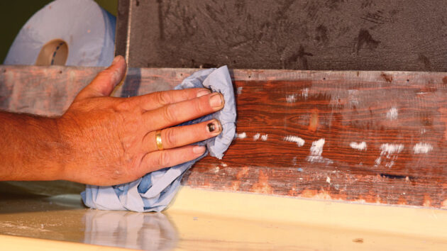 A man cleaning wood on a boat