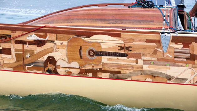 Close up of the hull of Collective Spirit yacht showing a guitar and a violin