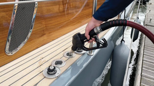A man using a marine diesel pump to fill up his boat