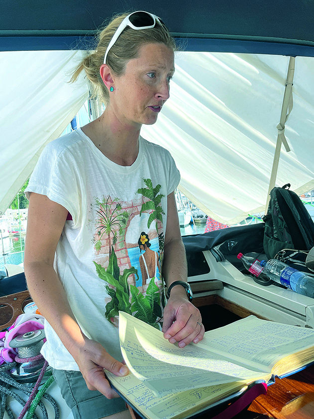 A transatlantic skipper looking at their log book on their boat