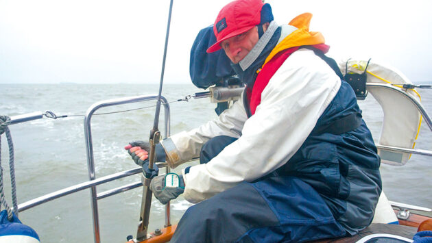 a man tightening the backstay on a yacht to help control weather helm