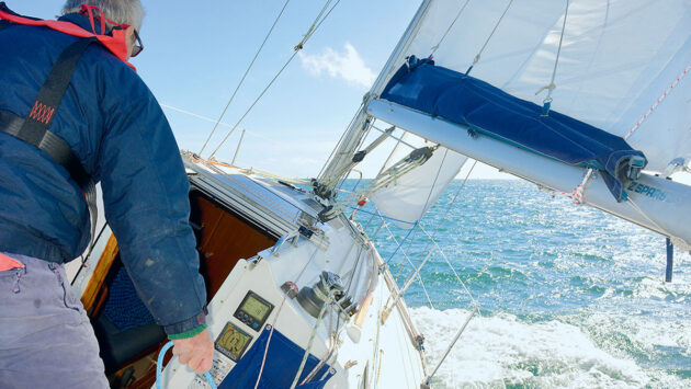 A skipper in the cockpit of a boat