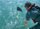 A man trying to untangle a lobster pot mark from a propeller