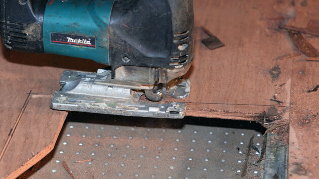 A man using a jigsaw to cut wood